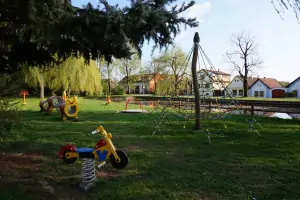 na návsi se nachází dětské hřiště - chalupa Novosedly nad Nežárkou je vidět v dálce