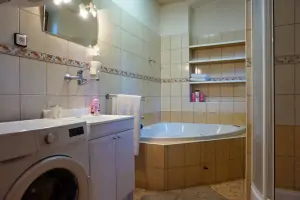 koupelna se sprchovým koutem, vanou, umyvadlem, WC a pračkou v přízemí