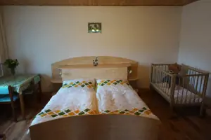 ložnice s dvojlůžkem a dětskou postýlkou v přízemí
