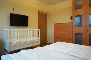 ložnice s dvojlůžkem a dětskou postýlkou v podkroví