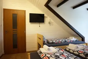 ložnice s dvojlůžkem, lůžkem a TV v podkroví