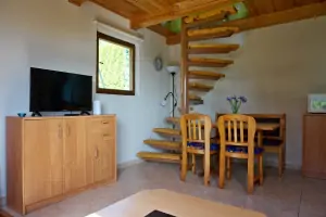 obytný pokoj - TV, jídelní kout a točité schody vedoucí do podkrovní otevřené ložnice