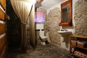 kamenná koupelna se sprchovým koutem, umyvadlem a WC