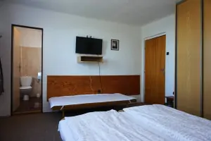 ložnice se 3 lůžky, TV a koupelnou v prvním patře