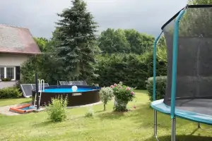 trampolína a vzadu bazén na zahradě chalupy