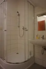 obytné podkroví nad společenskou místností: koupelna se sprchovým koutem a umyvadlem