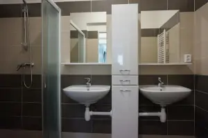 koupelna se sprchovým koutem a 2 umyvadly u 2 3-lůžkových ložnic v prním patře