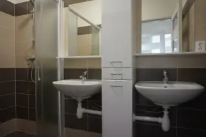 koupelna se sprchovým koutem a 2 umyvadly u 2 2-lůžkových ložnic v prním patře