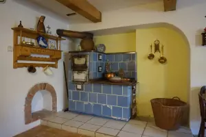 chalupářskou atmosferu dekorativně dokreslují kachlová kamna v obytné kuchyni