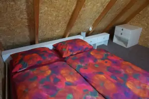 ložnice s dvojlůžkem a válendou v podkroví