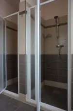 koupelna se 2 sprchovými kouty, 3 umyvadly, WC a pračkou