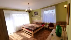 ložnice s dvojlůžkem a dětskou postýlkou v prvním patře