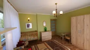 ložnice s dvojlůžkem a dětskou postýlkou v prvním patře
