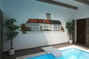 stěnu u bazénu zdobí kresba zámku v Polici