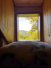 výhled z okna z ložnice s dvojlůžkem a lůžkem