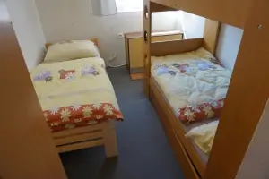 ložnice s patrovou postelí a 2 lůžky v podkroví