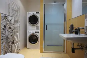 koupelna se sprchovým koutem, umyvadlem, WC, pračkou a sušičkou 