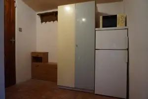 lednice s mrazícím boxem a mikrovlnná trouba v chodbě