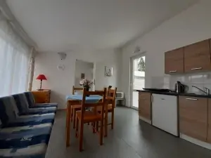 apartmán vlevo: obytná kuchyně s jídelním koutem, gaučem a kuchyňskou linkou 