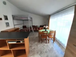 apartmán vpravo: pokoj s jídelním koutem, kuchyňskou linkou, 2 samostatnými lůžky a patrovým dvojlůžkem