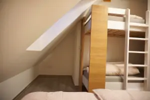 dvojlůžko a patrová postel v ložnici 2-pokojového apartmánu v podkroví