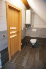 koupelna se sprchovým koutem, umyvadlem a WC ve 2-pokojovém apartmánu v podkroví