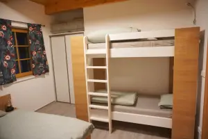 dvojlůžko a patrová postel v ložnici 2-pokojového apartmánu v přízemí