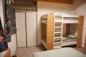 dvojlůžko a patrová postel v ložnici 2-pokojového apartmánu v přízemí