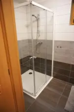 koupelna se sprchovým koutem a umyvadlem ve 2-pokojovém apartmánu v přízemí