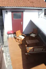 dřevěná veranda s nábytkem a přenosným grilem