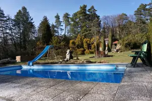 zahradě vévodí venkovní bazén se skluzavkou, najdete u něj i vodopád a nejedno venkovní posezení