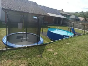 nadzemní bazén, skluzavka, houpačka a trampolína na zahradě
