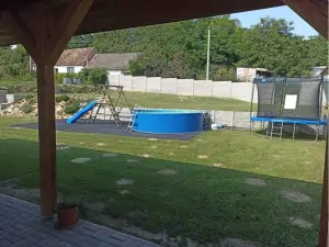 nadzemní bazén, skluzavka, houpačka a trampolína na zahradě