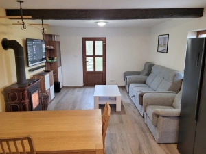 sedací souprava, krbová kamna a TV v obytné kuchyni