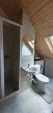 koupelna se sprchovým koutem, umyvadlem, WC a pračkou v podkroví