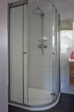 koupelna se sprchovým koutem, umyvadlem a WC v podkroví chaty 