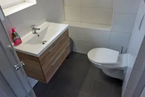 koupelna se sprchovým koutem, umyvadlem a WC v podkroví chaty