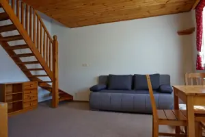 mezotenová ložnice - pokoj s gaučem, stolem, židlemi a TV