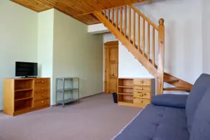 mezotenová ložnice - pokoj s gaučem, stolem, židlemi a TV