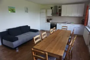 kuchyňská linka, stůl s židlemi a sedací souprava v obytné kuchyni