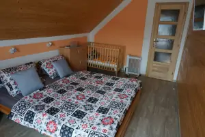 ložnice s dvojlůžkem, dětskou postýlkou a TV