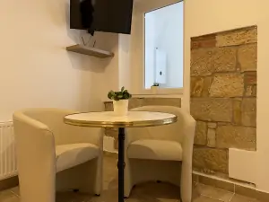 stolek, křesílka a TV v apartmánu