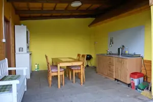 venkovní kuchyně s jídelním stolem a židlemi