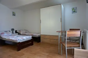 2 lůžka, skříň, stolek a 2 židle v apartmánu