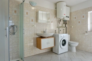 koupelna se sprchovým koutem, umyvadlem, WC a pračkou