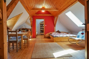 průchozí ložnice s dvojlůžkem, lůžkem a stolem s židlemi