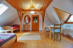 průchozí ložnice s dvojlůžkem, lůžkem a stolem s židlemi