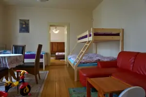 průchozí ložnice s patrovou postelí pro 3 osoby, lůžkem, gaučem a hračkami pro děti
