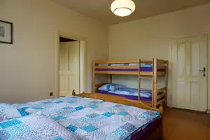 průchozí ložnice s dvojlůžkem a patrovou postelí v podkroví