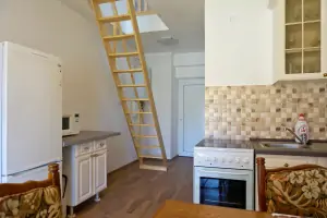 z kuchyně vedou příkré schody do podkrovní otevřené ložnice